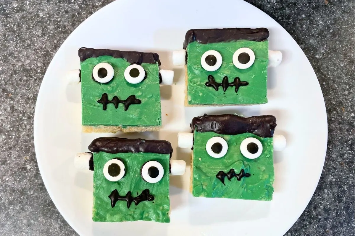 green and black frankenstein krispies treats on white plate