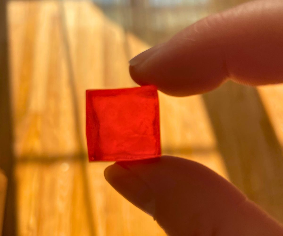 woman holding a mini red cube of soap