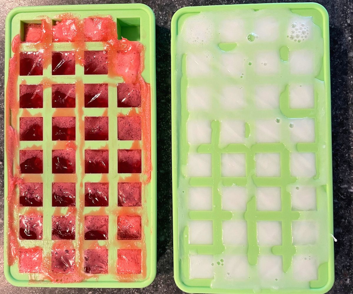 two cube molds filled with red soap and white soap
