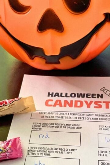 pumpkin pail of candy next to free printable game on dark table