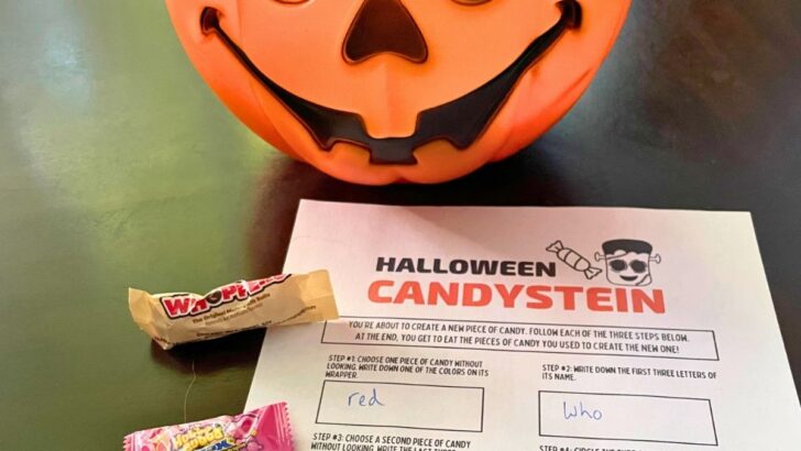 pumpkin pail of candy next to free printable game on dark table