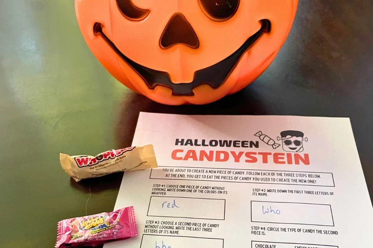 pumpkin pail of candy next to free printable game on dark table