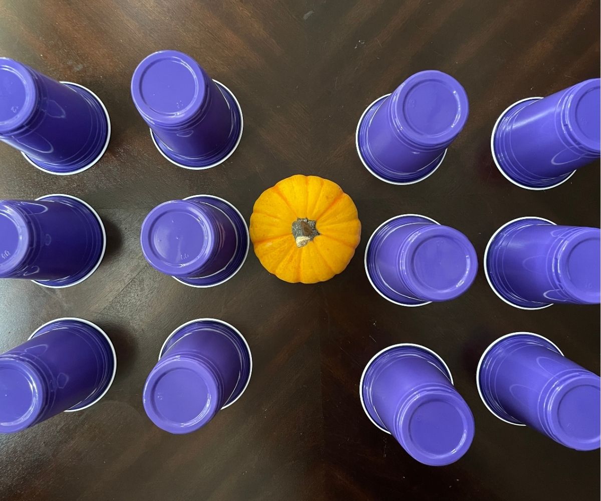 three rows of dark purple cups with candy inside, turned upside down