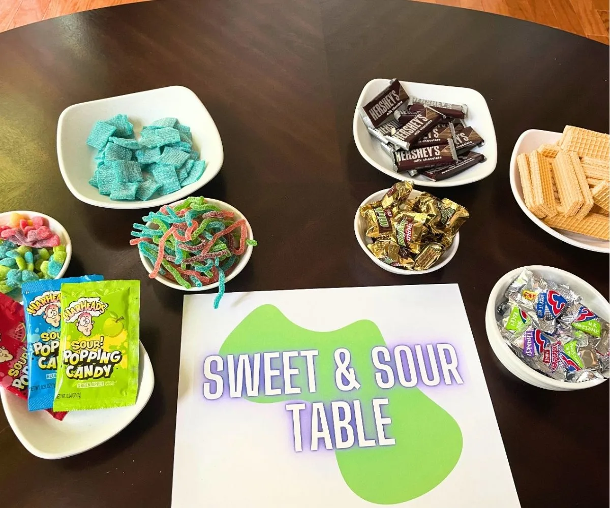 table with sign Sweet & Sour Table, with bowls of sweets and then sour candies