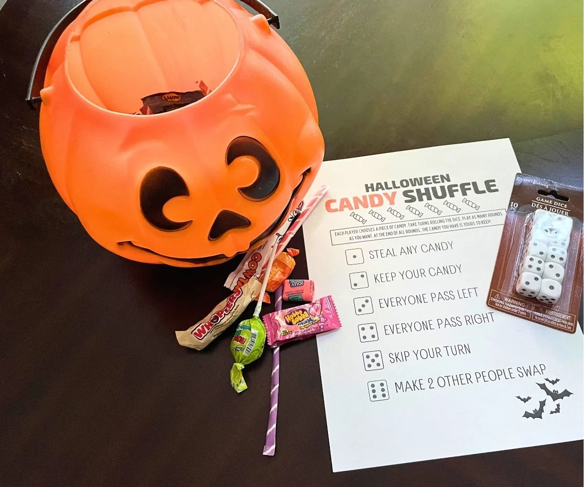 Halloween candy shuffle game printable with candy, dice, and pumpkin pail