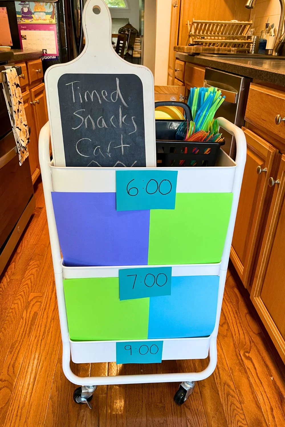 timed snacks cart three tiers with colorful pieces of paper hiding what's inside each tier, and a time slot on the outside of each