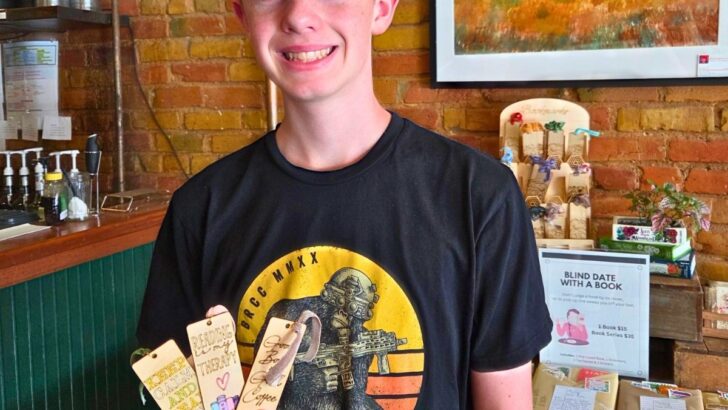 teen boy with handmade CO2 laser bookmarks at a shop