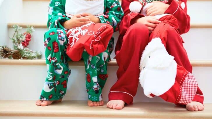 two kids in Christmas pajamas on stairs