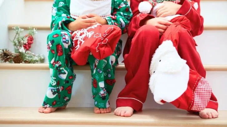 two kids in Christmas pajamas on stairs