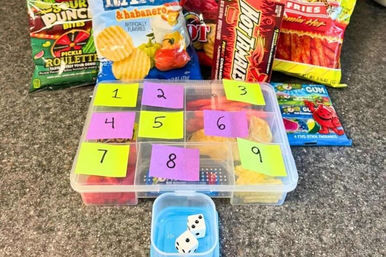 tacklebox with colored and numbered post its on outside, in front of dice and lots of extreme flavored snacks