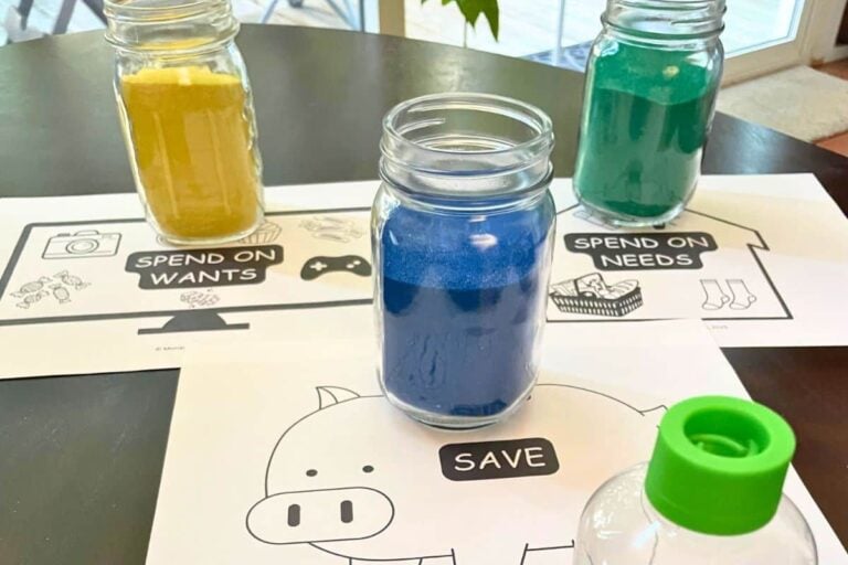 three colored sand jars representing needs, wants, and saving money