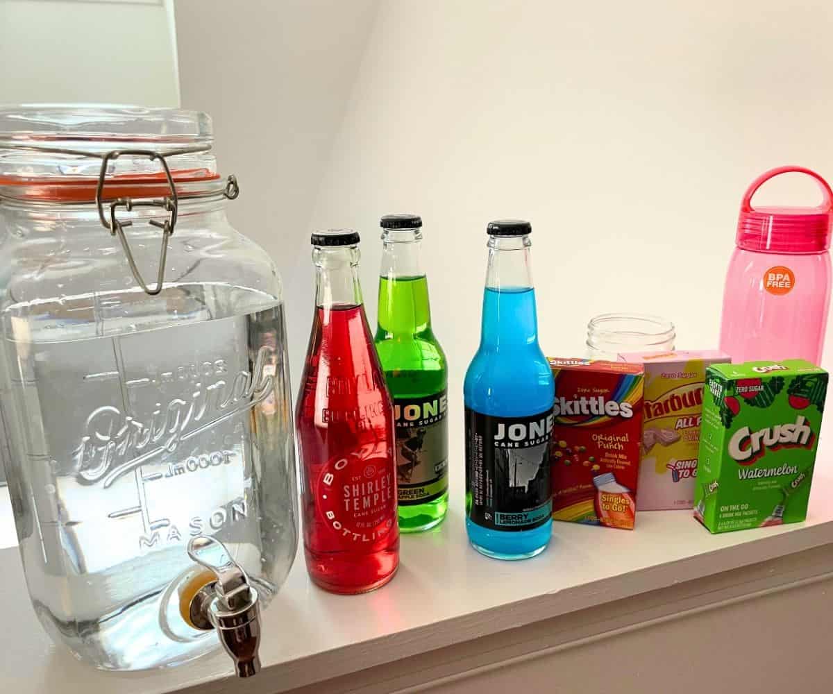 big jug of water, next to lots of individual colorful drinks and drink mixes