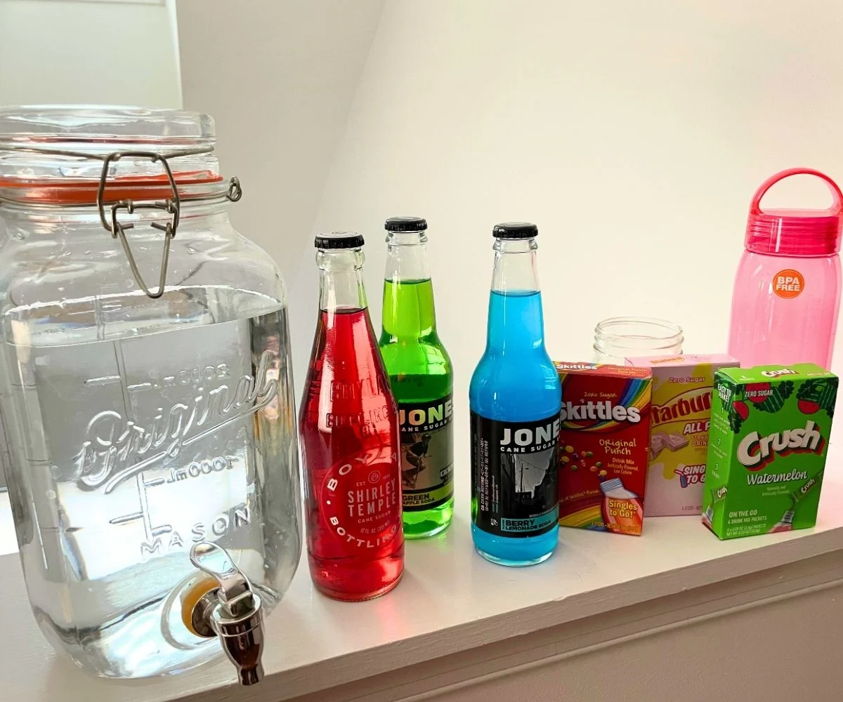 big jug of water, next to lots of individual colorful drinks and drink mixes