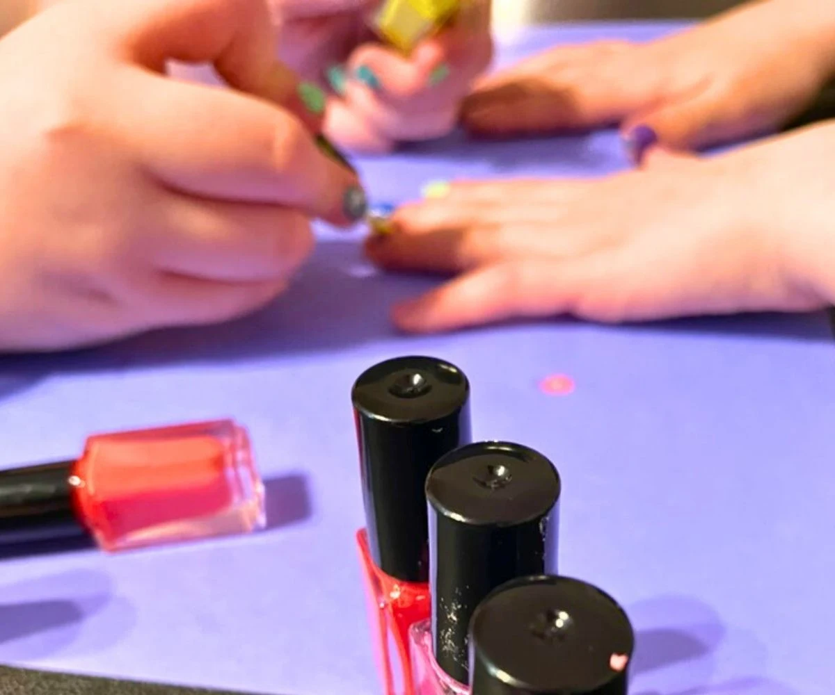 tween girl painting other tween girl's nails