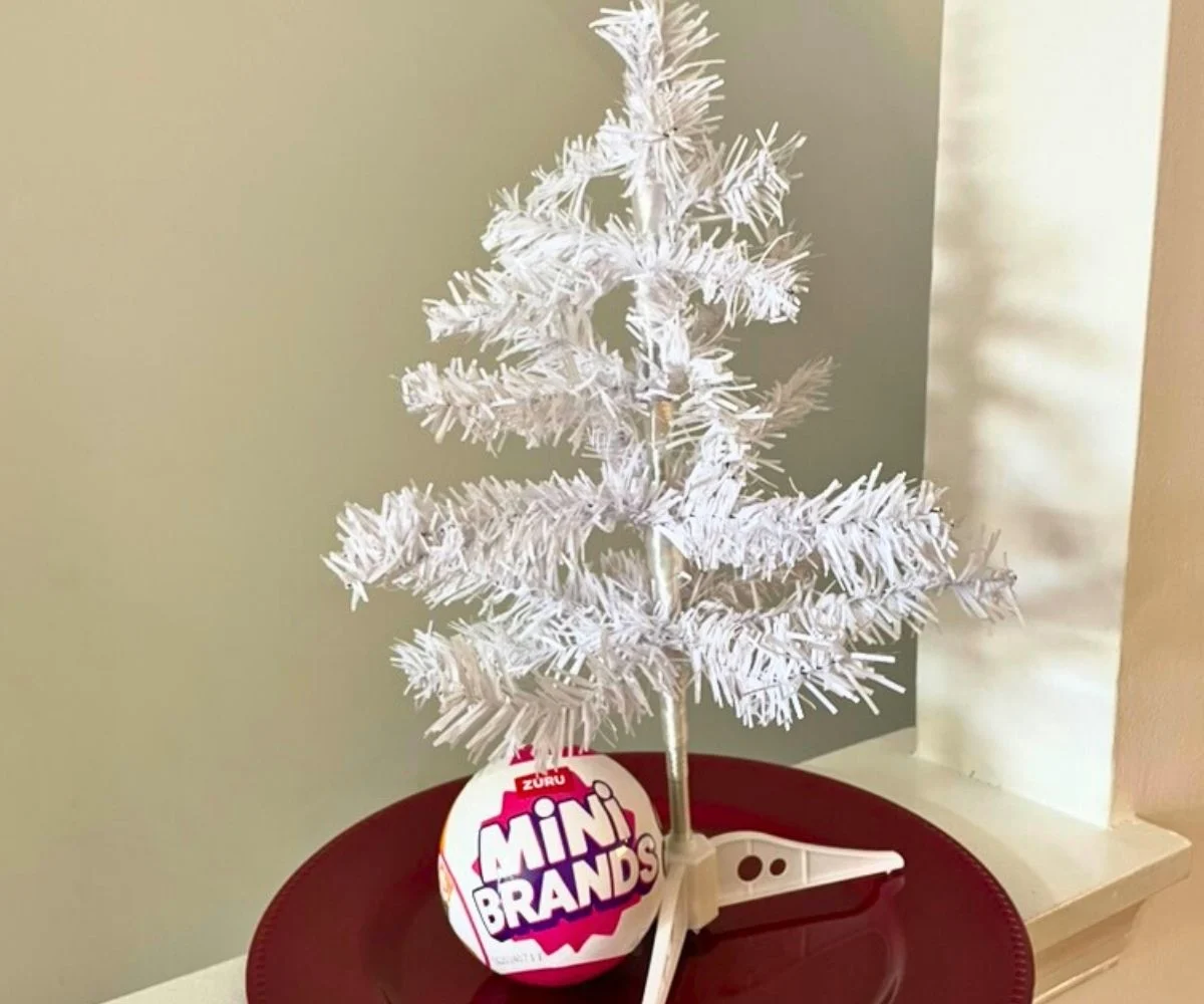 undecorated white mini tree on red charger plate with mini-brands package