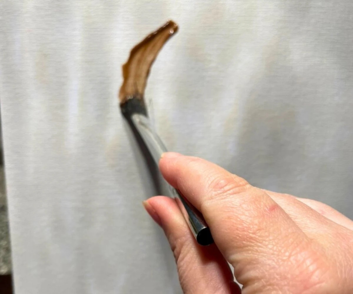 person painting the chocolate pudding on a canvas