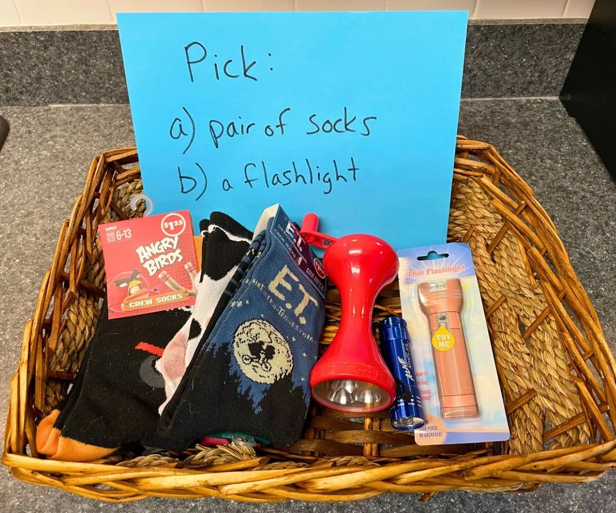 wooden basket filled with flashlights and fun socks, and a sign: Pick a a) pair of socks b) a flashlight