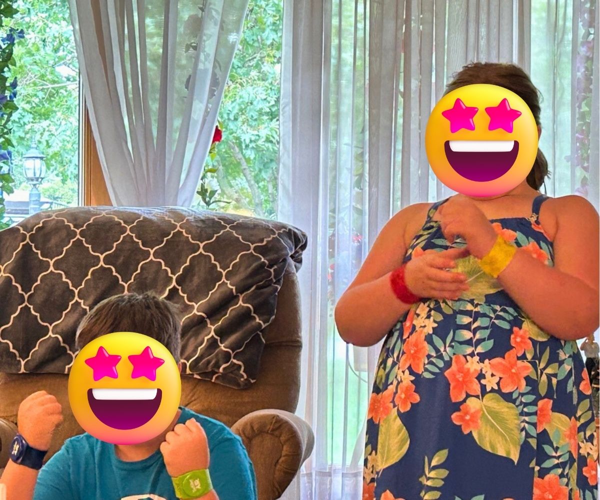 two tweens with Air Twister bands on arms playing, with emojis for faces
