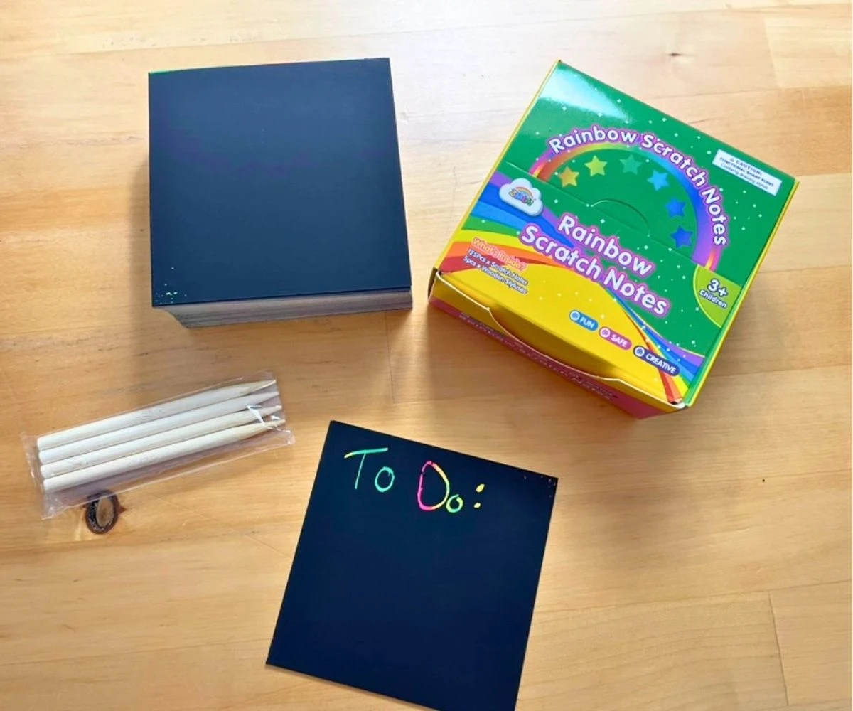 small black notes with wooden pencils to scratch them with