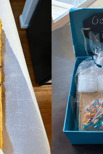 blue box with prepackaged gourmet s'mores kits in it, and a foot long cookie bar in someone's hand