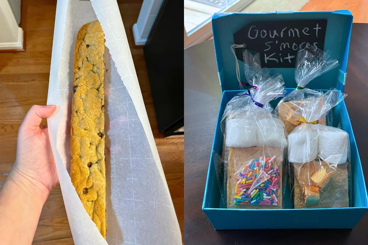 blue box with prepackaged gourmet s'mores kits in it, and a foot long cookie bar in someone's hand