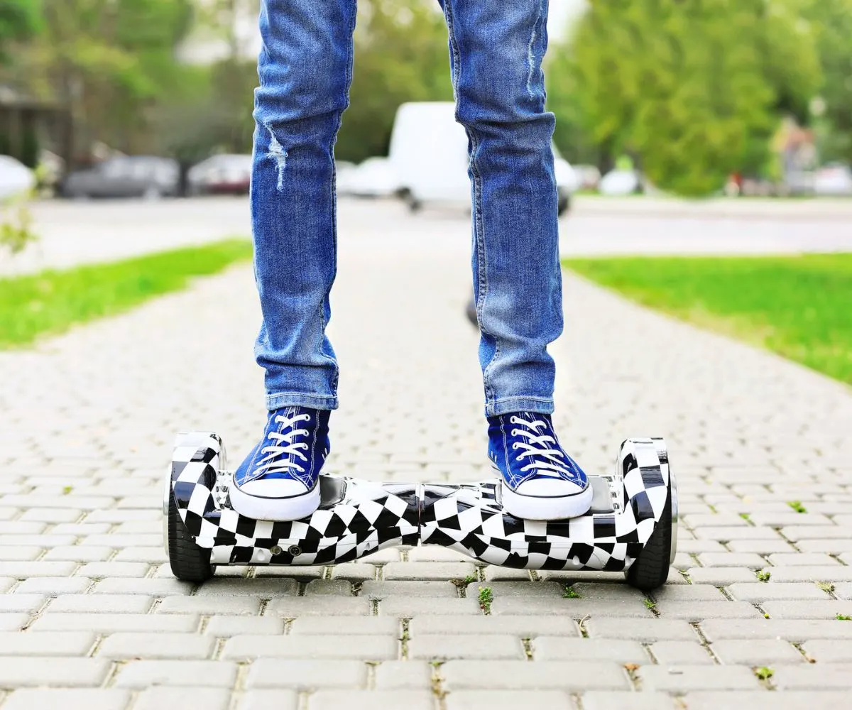 Teen in jeans on checkered hoverboard