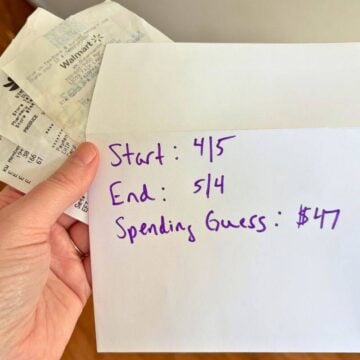 woman holding envelope and receipts with dates on the outside of it and estimated $47 in spending