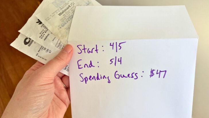 woman holding envelope and receipts with dates on the outside of it and estimated $47 in spending