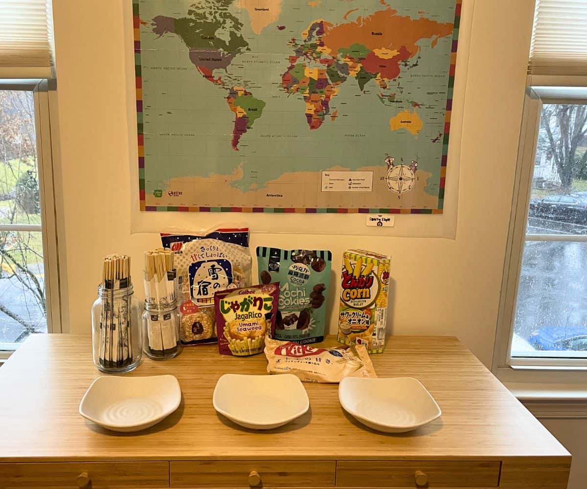 large map of the world on wall, and table with chopsticks, tasting bowls, and lots of international snacks