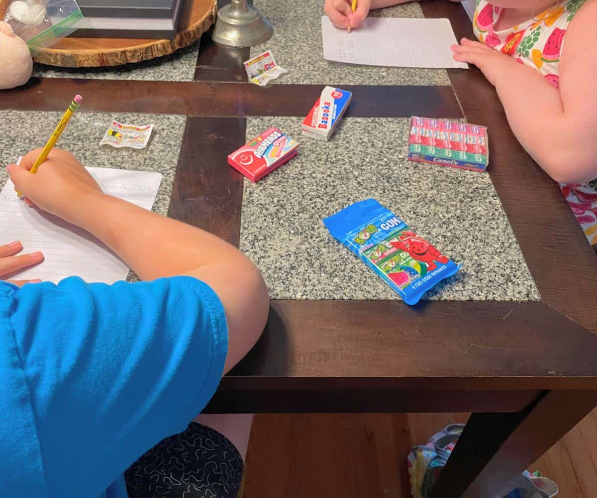 two preteens try out the gums and writing down their thoughts at table