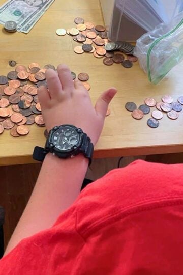 child counting coins and dollars on table to get ready for online shopping day spending