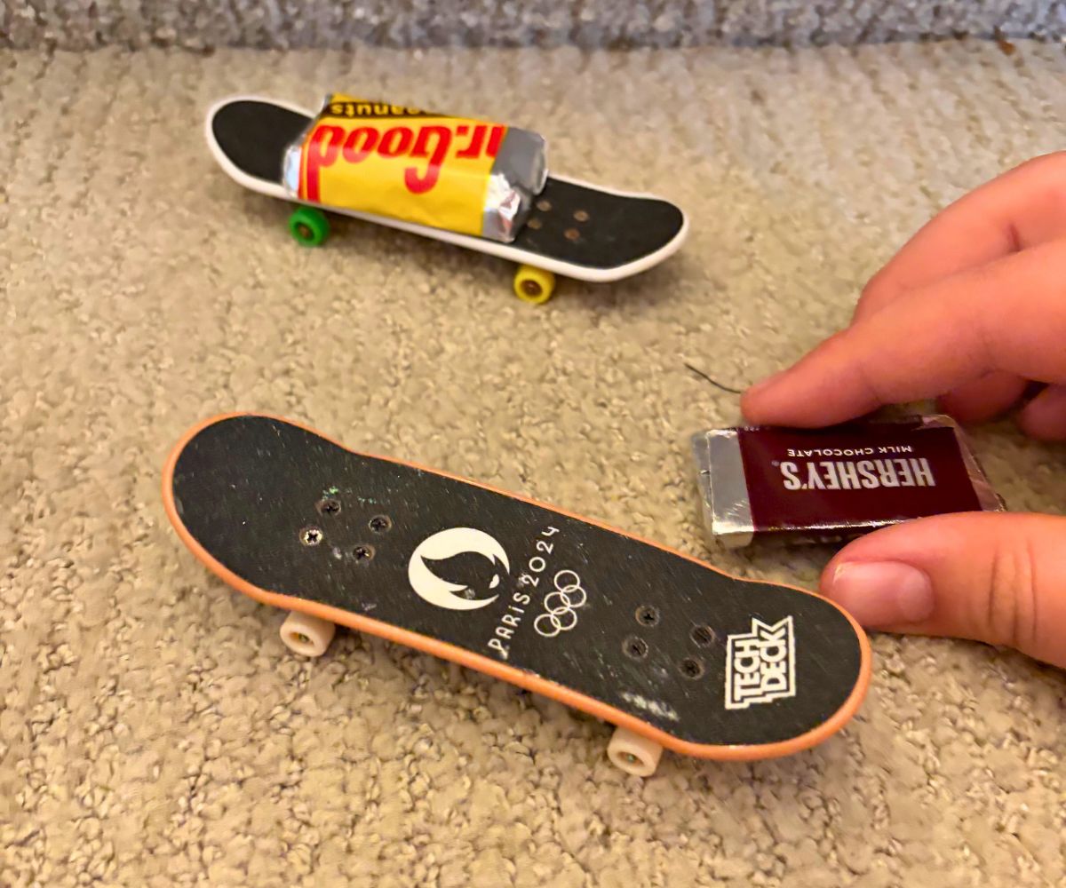 two tech decks on carpet, with one piece of candy on top of each