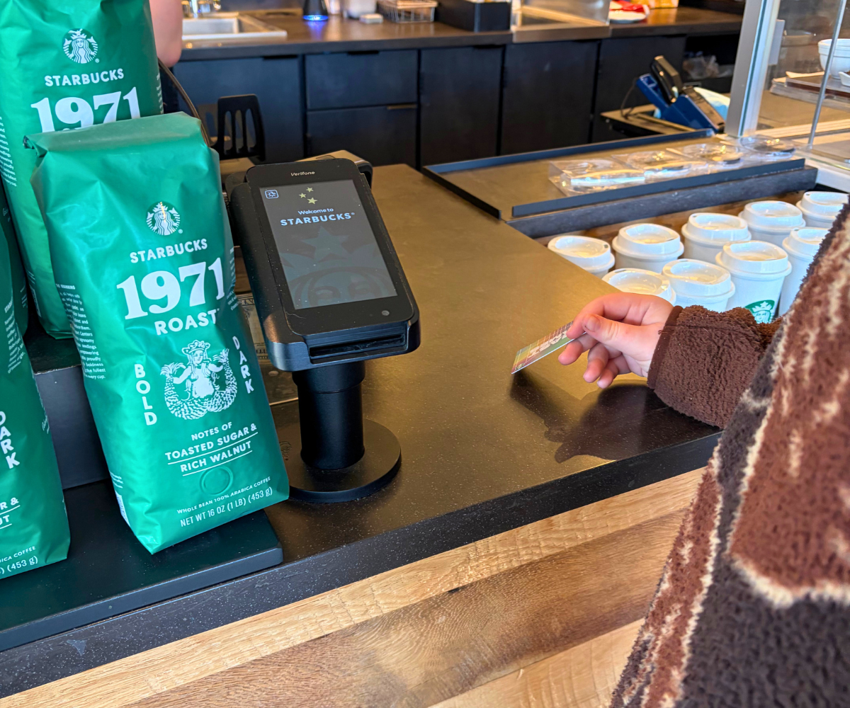 child at Starbucks handing over his Starbucks reward card