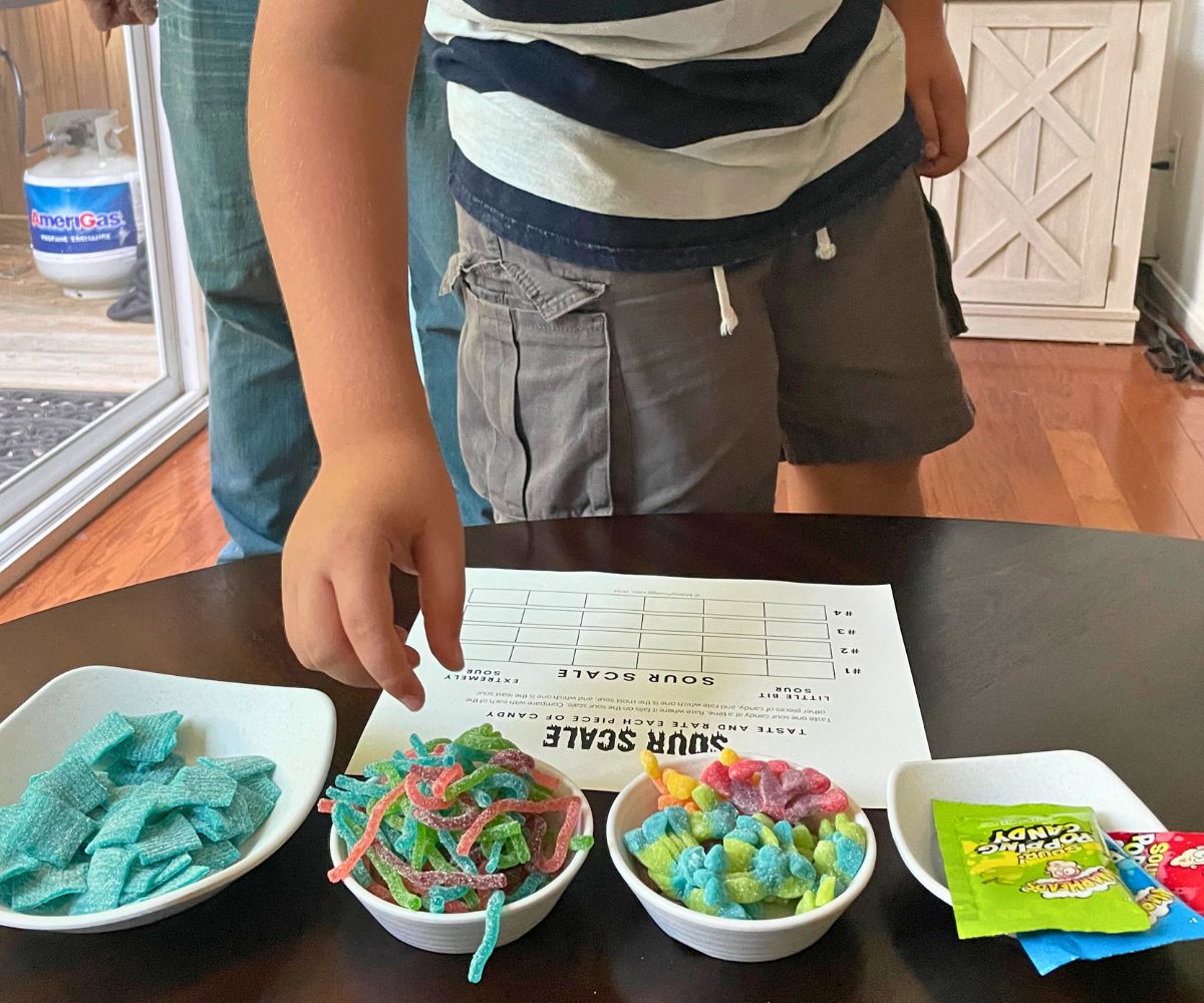 boy grabbing one of the four sour candies to fill out the sour scale with